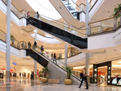 shopping mall with escalators and people shopping